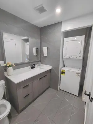 a bathroom with a sink and a washer and dryer at Niagara 3 Bed Unit Near the Falls in Niagara Falls