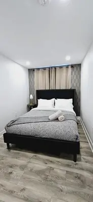 a bedroom with a large bed with a wooden floor at Niagara 3 Bed Unit Near the Falls in Niagara Falls