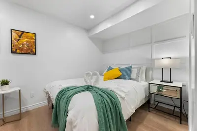 a bedroom with a bed with a green blanket on it at High Park Oasis Modern 1B1B, Kitchen, Laundry in Toronto