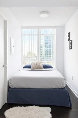 a bedroom with a large bed with a large window at RivetStays - Dan Leckie Suite in Toronto