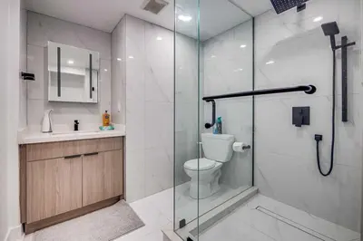 a bathroom with a shower and a toilet and a sink at Modern 2BR Unit Near the Falls in Niagara Falls
