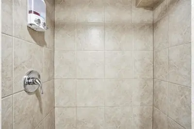 a bathroom with a shower with a tiled shower at 5 Bedroom House - 1 Block from the Falls in Niagara Falls
