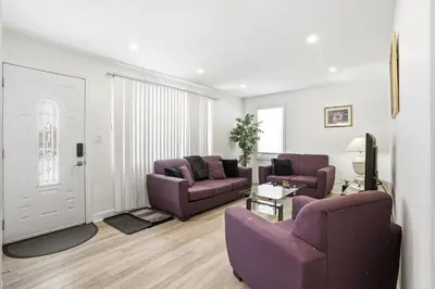 a living room with two purple couches and a tv at 5 Bedroom House - 1 Block from the Falls in Niagara Falls