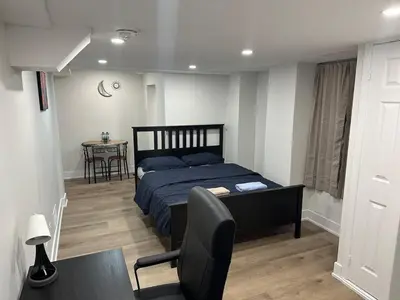 a bedroom with a bed and a table and a chair at Cozy Basement Studio with Private Bathroom and Kitchen in Vaughan