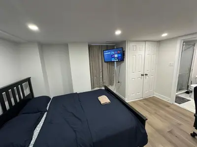 a bedroom with a bed with a tv on the wall at Cozy Basement Studio with Private Bathroom and Kitchen in Vaughan