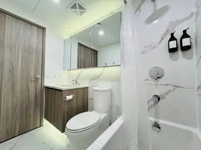 a white bathroom with a toilet and a sink at Luxury 76 floor 2B2B Downtown Toronto Skyline View in Toronto