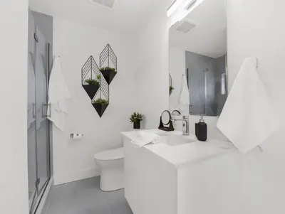 a white bathroom with a toilet and a sink at 2BR Penthouse Rooftop, Parking, Close to the Falls in Niagara Falls