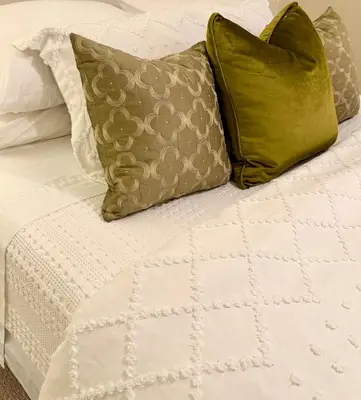 a white bed with green pillows on it at Charming private Guest Suite near Thermea Spa in Whitby