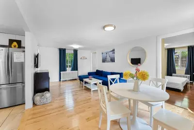 a living room with a table and a blue couch at Cozy Family Retreat Minutes From the Falls and Pet Friendly in Niagara Falls