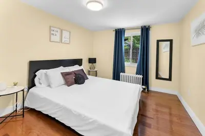 a bedroom with a large white bed with blue curtains at Cozy Family Retreat Minutes From the Falls and Pet Friendly in Niagara Falls