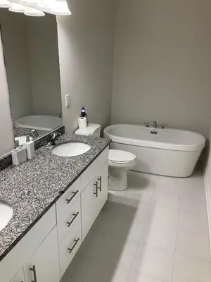 a bathroom with a tub and a toilet and a sink and a bath tub at Modern Luxury Townhome with 2BR Balcony plus Parking - Happy Oaks in Oakville