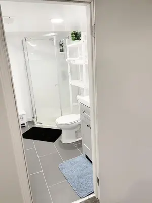 a white bathroom with a toilet and a shower at ClassicPavillion INN in Bowmanville