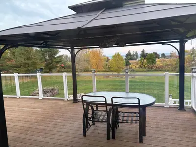 a table and two chairs under an umbrella on a deck at Lakeview in Colborne
