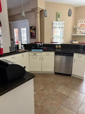 a kitchen with white cabinets and a black counter top at Lakeview in Colborne