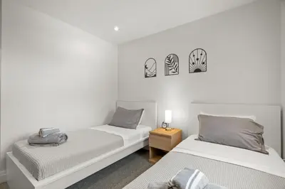 two beds in a room with white walls at 4BR Family Home - Dog-Friendly, Huge Yard, 5 Beds in Pickering
