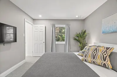 a bedroom with a large bed and a window at 4BR Family Home - Dog-Friendly, Huge Yard, 5 Beds in Pickering