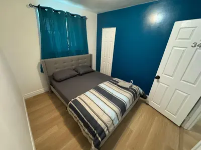 a bedroom with a bed and a blue wall at Private Room Near Airport D34 in Mississauga