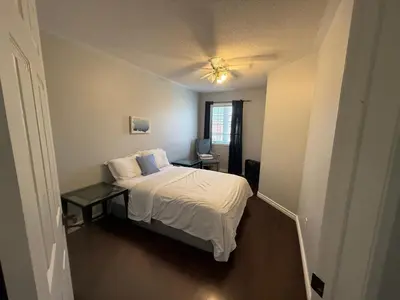 a small bedroom with a bed and a table at Spacious Three Bedroom House Wifi Parking in Milton