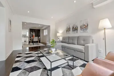 a living room with a couch and a table at Modern 4BR Retreat with Premium Comforts & Parking in Richmond Hill