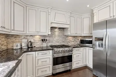 a kitchen with white cabinets and a stainless steel refrigerator at Modern 4BR Retreat with Premium Comforts & Parking in Richmond Hill
