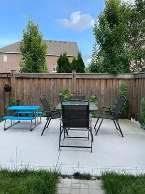 a patio with a table and chairs and a fence at One bedroom and studio Basement Apartment unit sleeps 4 in Oakville