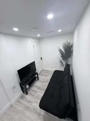 a living room with a couch and a tv at The Urban Executive Suite - Premier Kitchener Loft in Kitchener