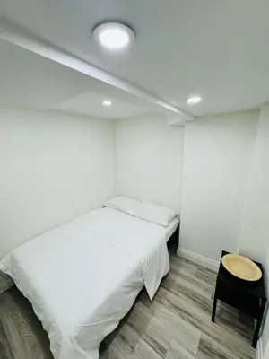 a white bedroom with a bed and a table at The Urban Executive Suite - Premier Kitchener Loft in Kitchener