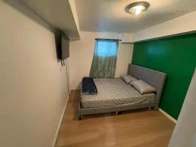 a small bed in a room with a green wall at Private Room Near Airport D39 in Mississauga