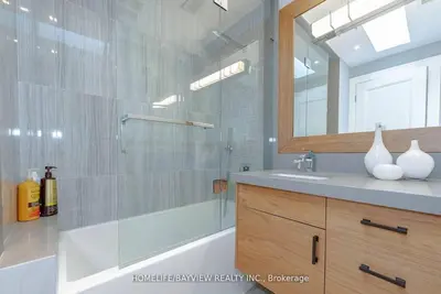a bathroom with a tub and a sink and a mirror at Luxury Modern Retreat in Richmond Hill in Richmond Hill
