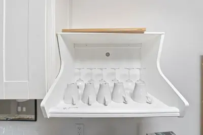 a white cabinet with four bottles in a kitchen at Tranquil Bliss Retreat 9 min to Falls with Free Parking in Niagara Falls