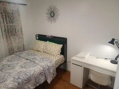 a small bedroom with a bed and a desk at The Taunton House in Ajax