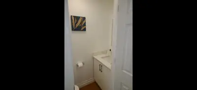 a white bathroom with a sink and a mirror at The Taunton House in Ajax