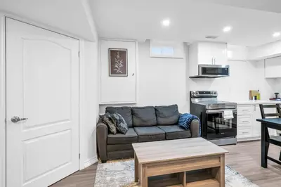 a living room with a couch and a kitchen at Newly Renovated 2BR Basement Suite, Private Entry in Pickering