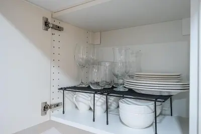a shelf with plates and wine glasses on it at Newly Renovated 2BR Basement Suite, Private Entry in Pickering