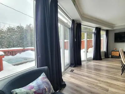 a living room with a large window and a couch at Private Ski Chalet Hot Tub & Mountain Views in Blue Mountains