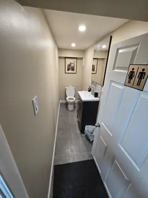 a bathroom with a toilet and a sink and a door at Bright Room in Walkout Basement in Pickering