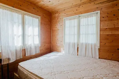a bedroom with a bed and two windows at Charming Lakeview Family Resort in Katchwanooka with Private BBQ and firepit in Lakefield