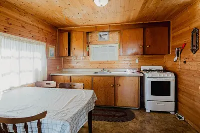 a small kitchen with a stove and a sink at Charming Lakeview Family Resort in Katchwanooka with Private BBQ and firepit in Lakefield