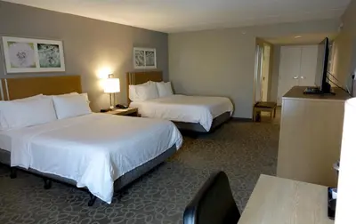 a hotel room with two beds and a table at Holiday Inn Express & Suites Oshawa Downtown - Toronto Area by IHG in Oshawa