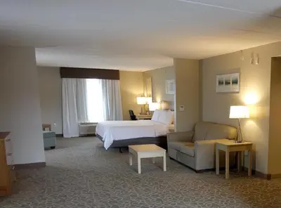 a hotel room with a bed and a couch at Holiday Inn Express & Suites Oshawa Downtown - Toronto Area by IHG in Oshawa