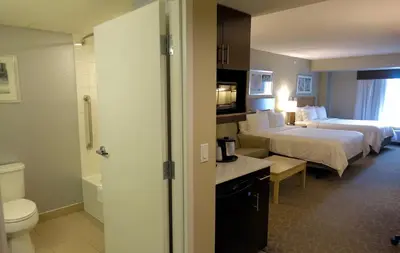 a hotel room with two beds and a bathroom at Holiday Inn Express & Suites Oshawa Downtown - Toronto Area by IHG in Oshawa