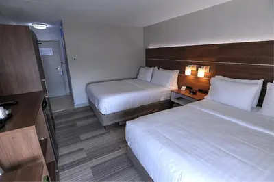 a hotel room with two beds and a television at Holiday Inn Express & Suites Toronto Airport West by IHG in Mississauga