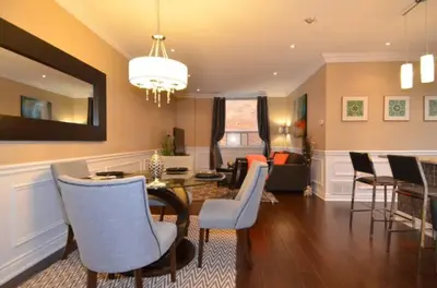 a living room with a dining table and chairs at The SoMa Furnished Residences in Hamilton