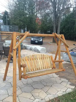 a wooden bench in a park with a car at Victoria Harbour Cottages in Victoria Harbour