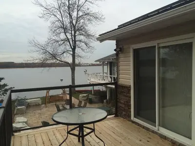 a balcony with a table and a view of the water at Victoria Harbour Cottages in Victoria Harbour