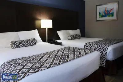 a hotel room with two beds and a lamp at Travellers Inn in Hanover