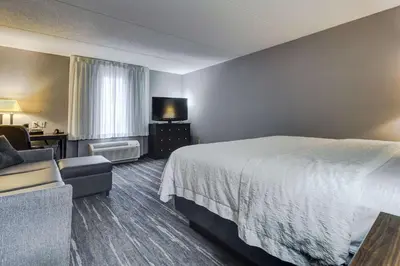 a hotel room with a bed and a chair at Hampton Inn & Suites by Hilton Brantford in Brantford