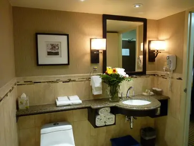 a bathroom with a sink and a toilet and a mirror at Holiday Inn Hotel Peterborough Waterfront by IHG in Peterborough