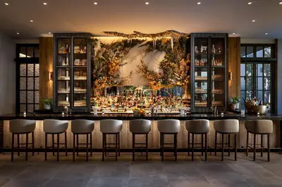 a bar with stools in front of a large mural at 1 Hotel Toronto in Toronto