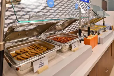 a buffet line with trays of food on a counter at Holiday Inn Express & Suites - Belleville by IHG in Belleville